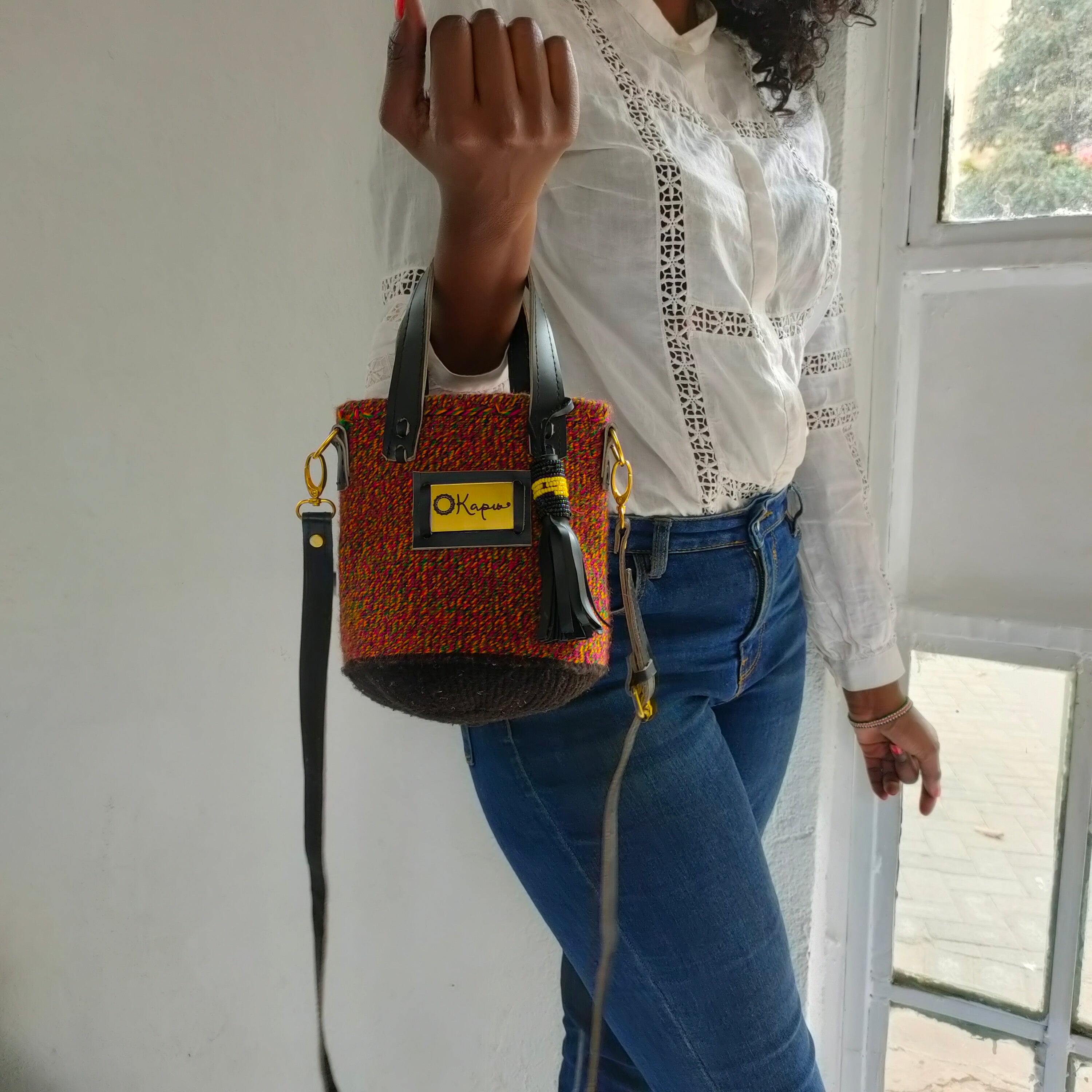 The small size of this stunning Okapu bag makes it an excellent 'going out' companion. A multi-colored piece with mostly burnt orange that says 'I am versatile and is sure to brighten the fits in your closet for both day and night activities  Its black leather trimmings include an adjustable strap to carry it over your shoulder or across your body. With the removable straps, you could just easily grab it with your hands with the top handles. 